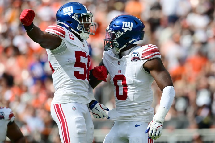 New York Giants linebacker Bobby Okereke (58) and linebacker Brian Burns (0) celebrate after Burns strip-sacked Cleveland Browns quarterback Deshaun Watson during the first half at Huntington Bank Field on September 22, 2024.