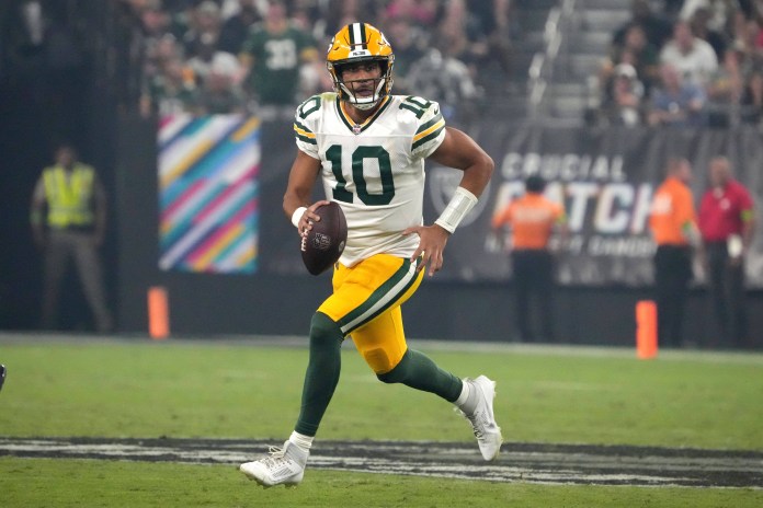 Green Bay Packers quarterback Jordan Love carries the ball