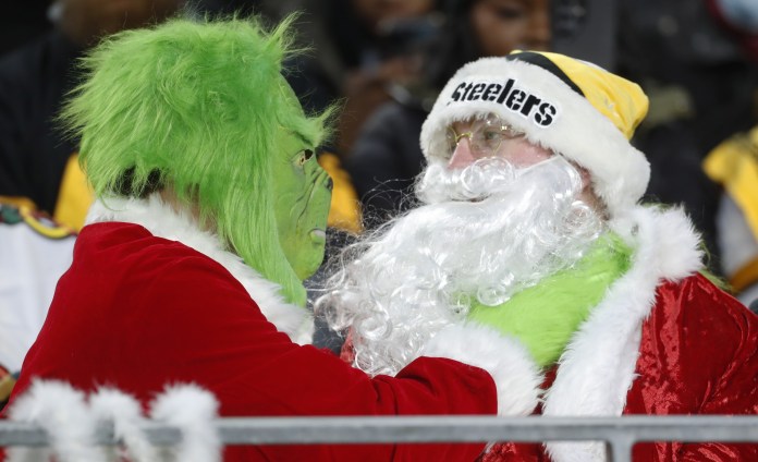 Fans dressed as Santa Claus and the Grinch cheer during the Pittsburgh Steelers vs. Cincinnati Bengals game at Acrisure Stadium on December 23, 2023