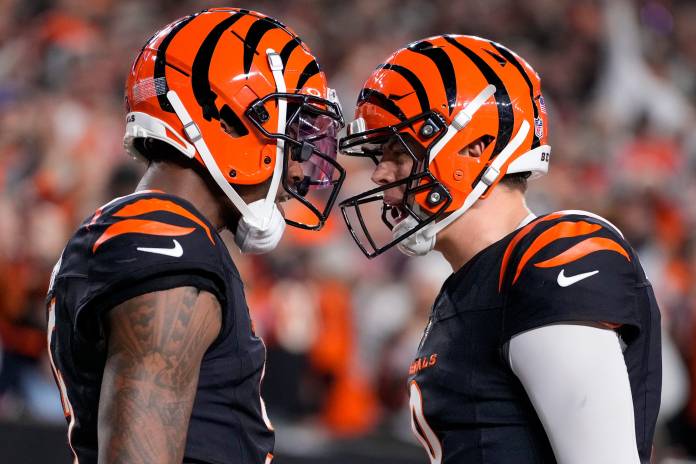 Bengals wide receiver Tee Higgins (5) and quarterback Joe Burrow (9) celebrate a fourth-quarter touchdown against the Broncos at Paycor Stadium on December 28, 2024.
