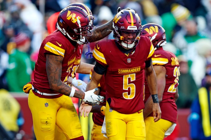 Washington Commanders quarterback Jayden Daniels (5) celebrates after throwing a fourth-quarter touchdown pass against the Philadelphia Eagles at Northwest Stadium on December 22, 2024.